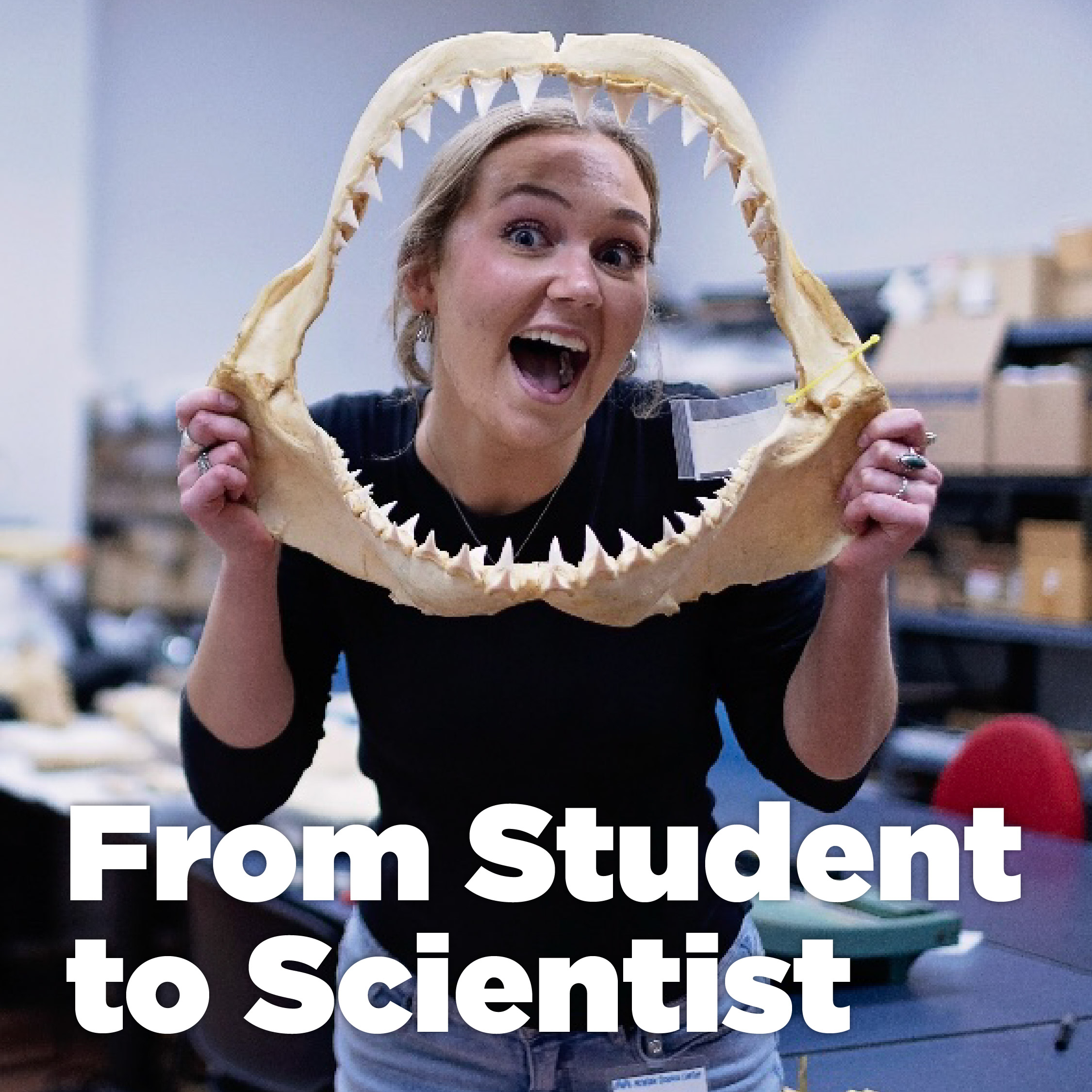 Person smiling through a shark jaw in a lab with the words "From Student to Scientist" over the picture.