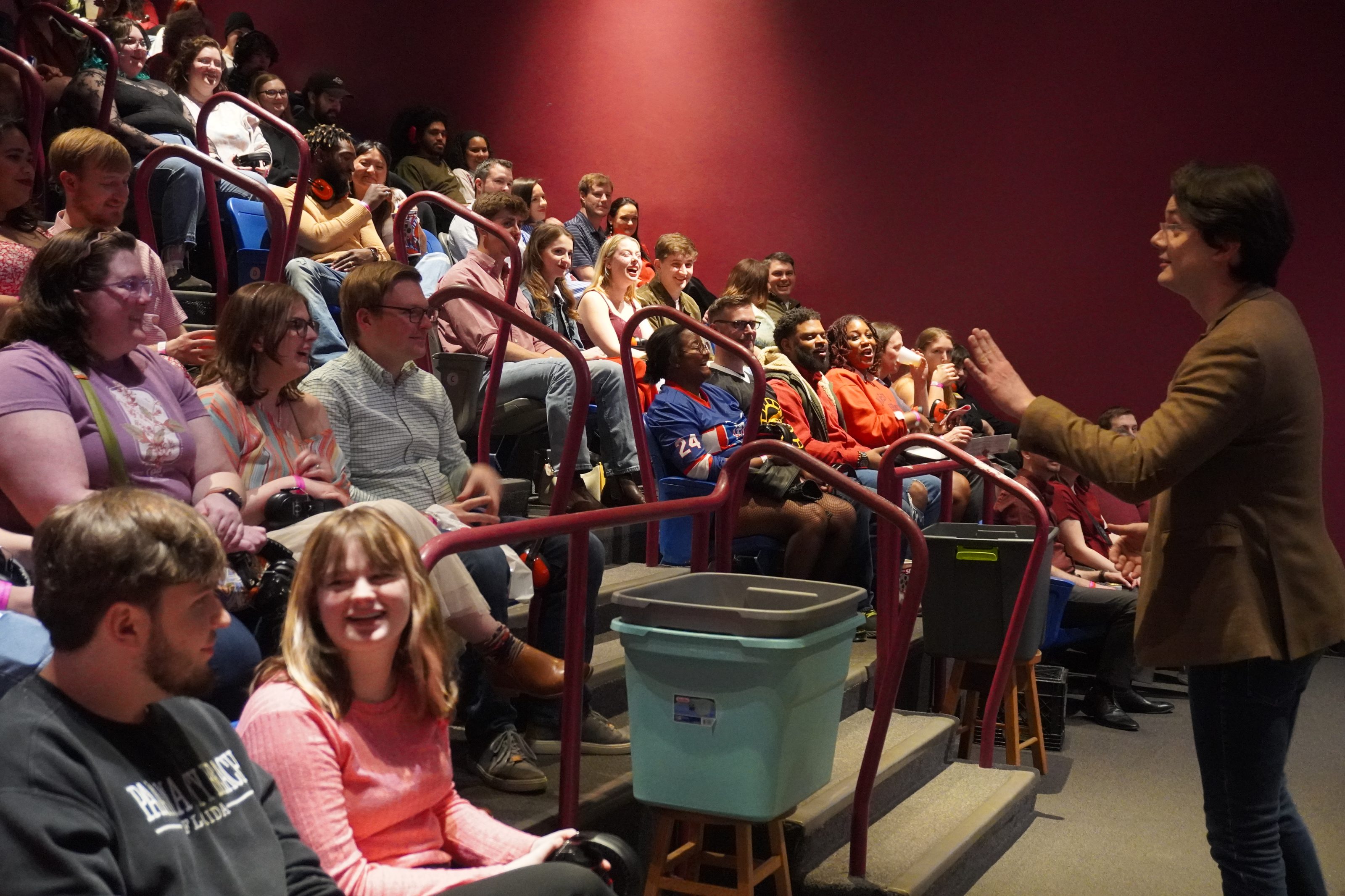 Interactive STEM show at children's science center: a presenter engages a packed auditorium of visitors.